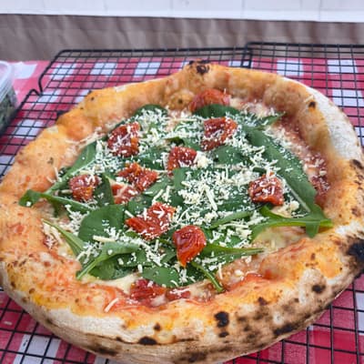 Pizza de rúcula com tomate seco e parmesão